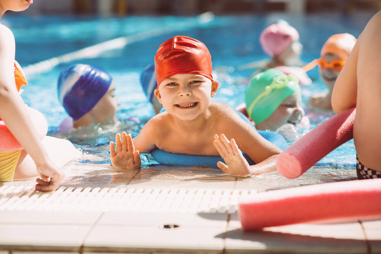 Strahlendes Kind beim Schwimmkurs – kids.kids.kids Wien