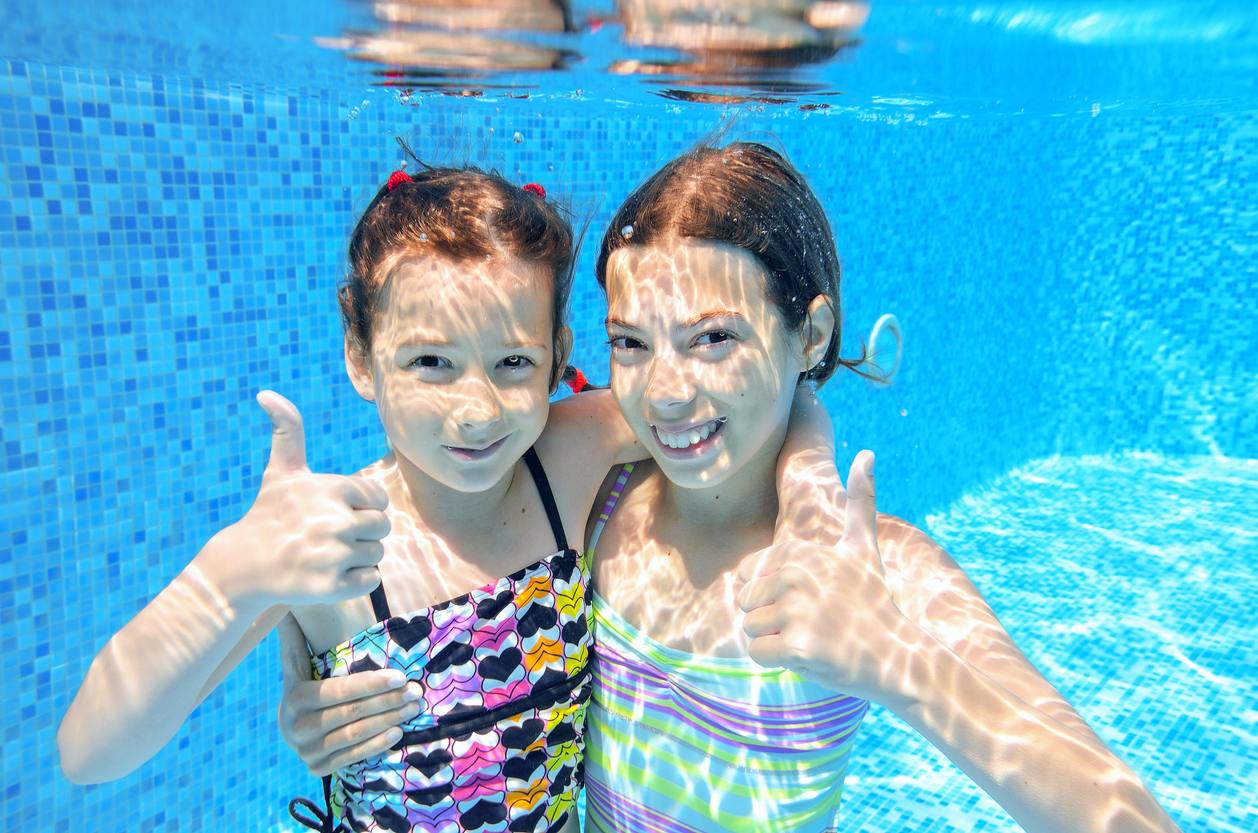 Glückliche Kinder beim Schwimmkurs